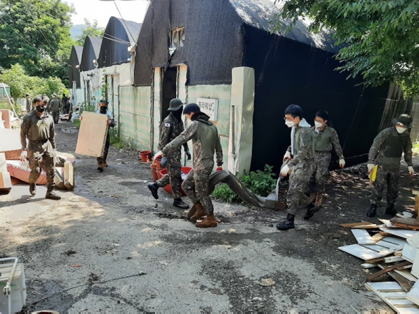 12일 침수피해를 입은 화훼농원에서 지원 나온 군인들이 쓰레기를 치우고 있다.